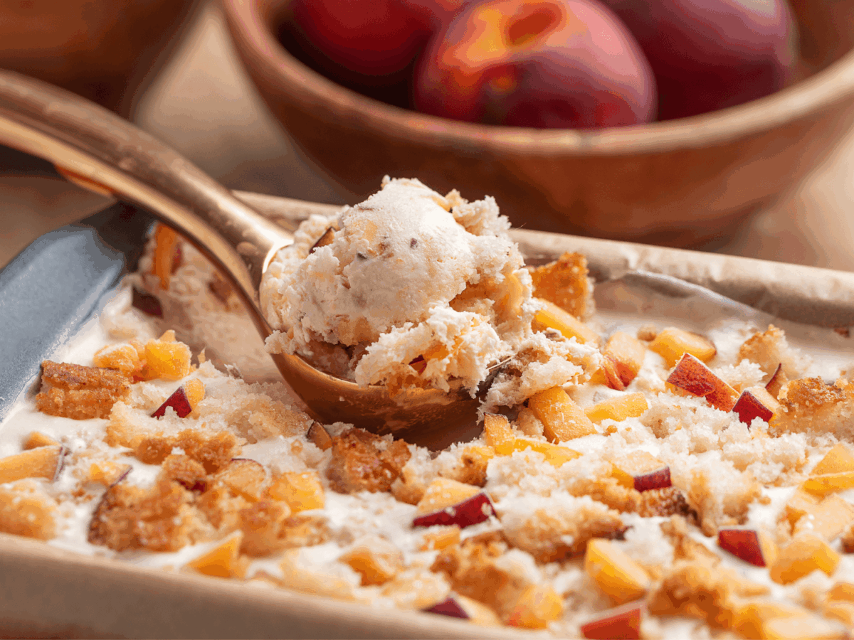 close up photo showing peach cobbler Ice Cream on an ice cream scoop