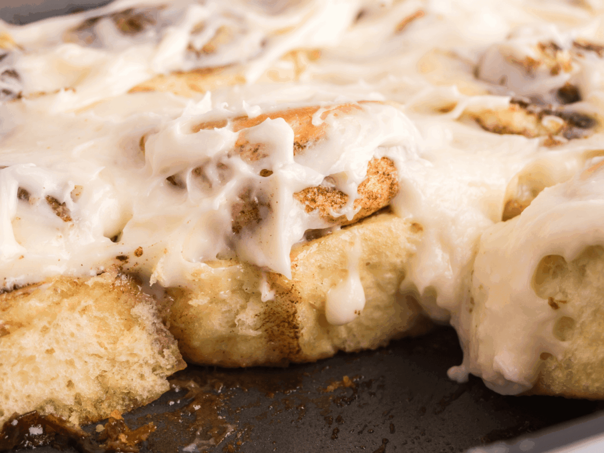close up photo showing the inside of cinnamon rolls in the baking pan