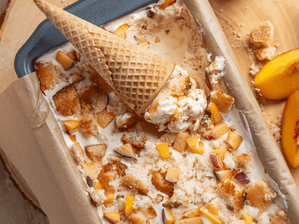 overhead photo showing an ice cream cone on top of a pan of peach cobbler Ice Cream