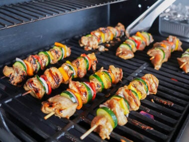 photo of chicken kabobs being turned on the grill