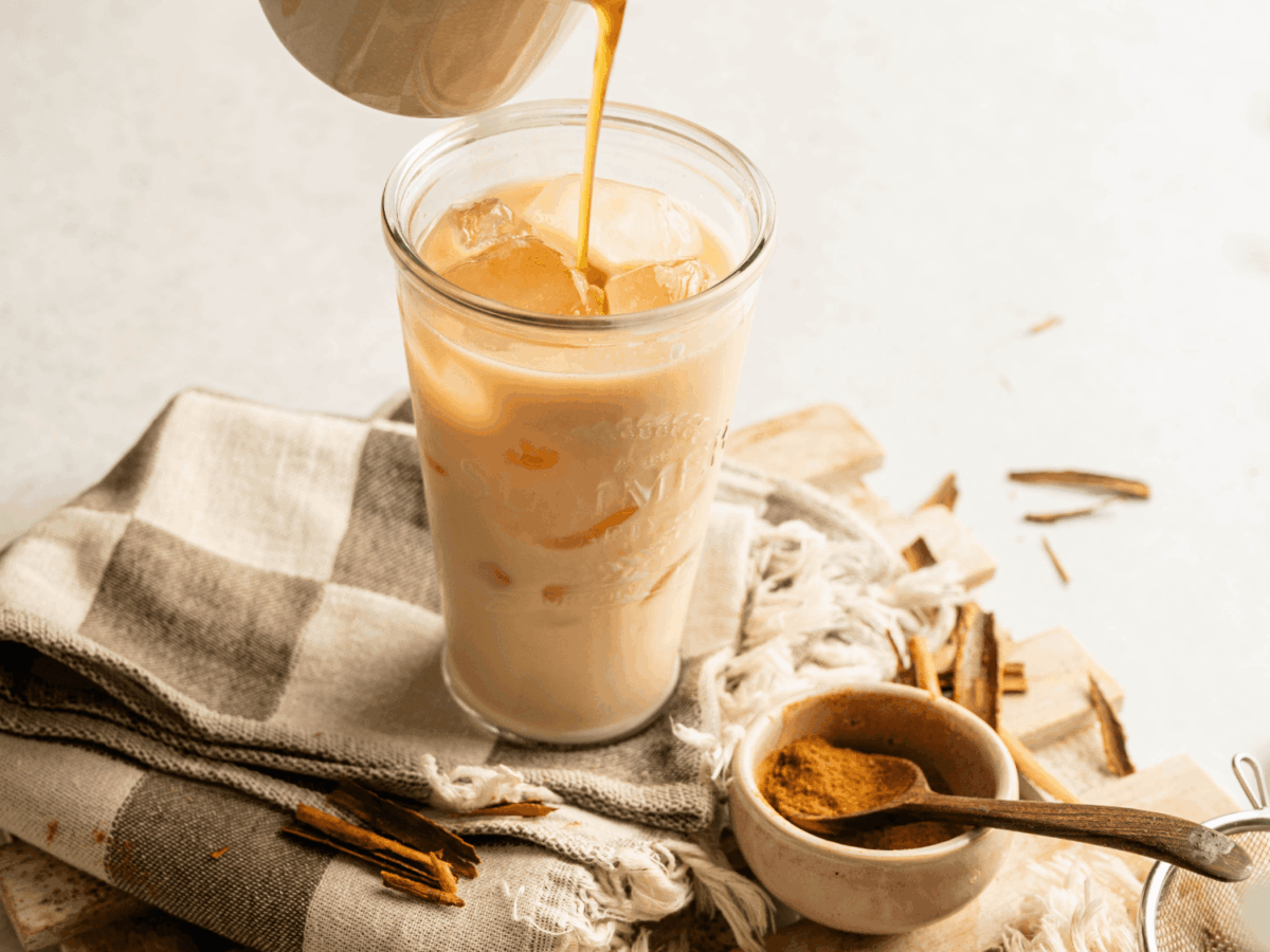 photo showing chai tea being poured into a glass cup