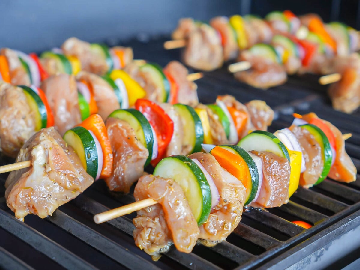 photo showing chicken kabobs cooking on the grill