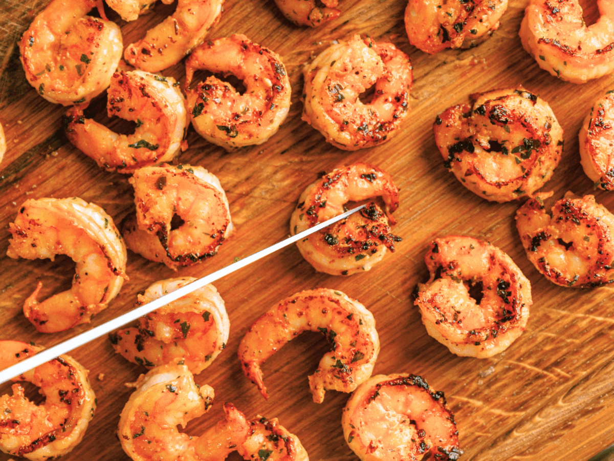 photo showing cooked shrimp on a wooden cutting board