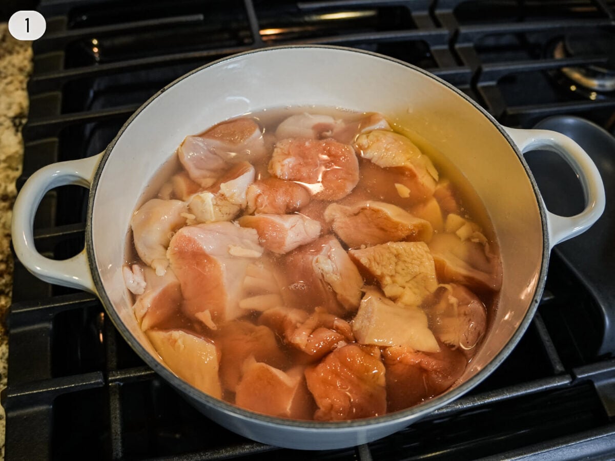 step 1 photo showing chicken sitting in a warm brine mixture in a pot