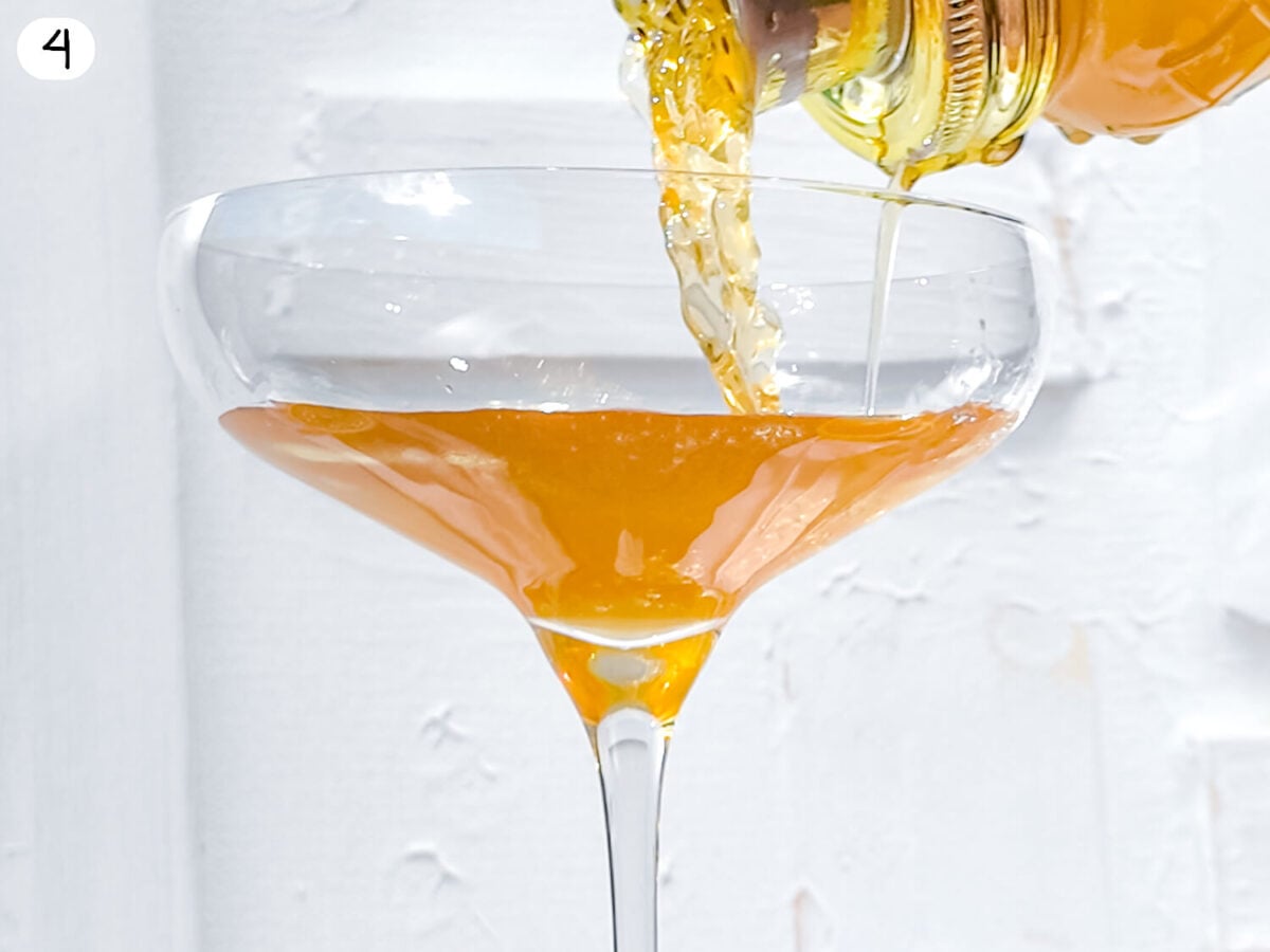 step 4 showing the Hennessy sidecar cocktail being poured from the shaker through a strainer into a coupe glass