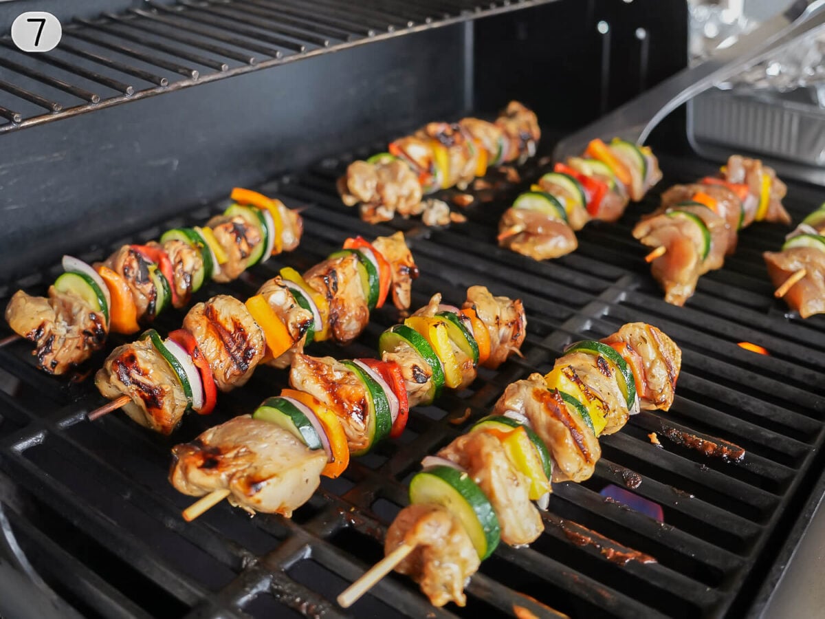step 7 photo showing chicken skewers cooking on the grill