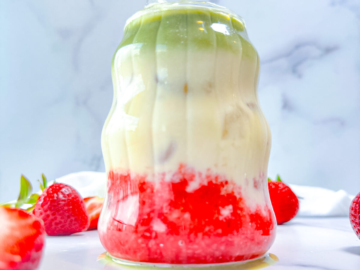 zoomed in photo of a strawberry matcha latte in a retro glass