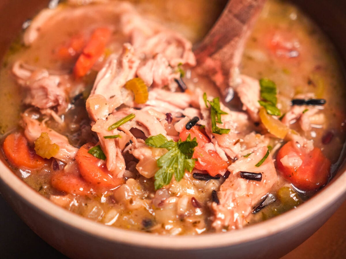 close up photo of chicken and wild rice soup in a brown bowl