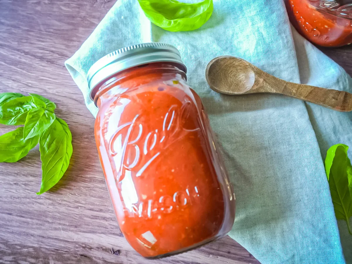 photo of marinara sauce in a mason jar on a linen napkin
