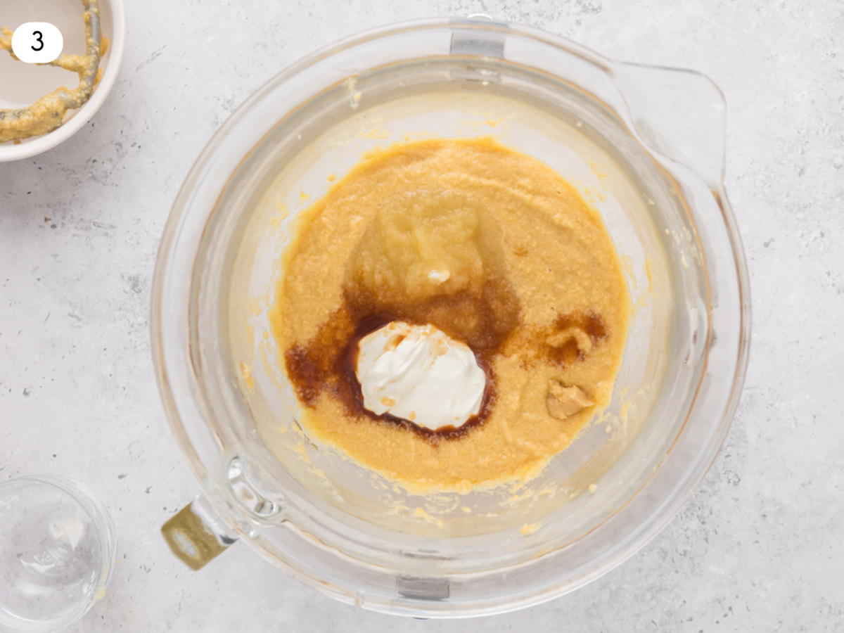 step 3 photo showing apple sauce, sour cream and vanilla extract being added to the batter
