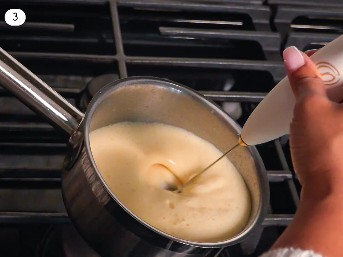 step 3 photo showing eggnog being mixed with a frother