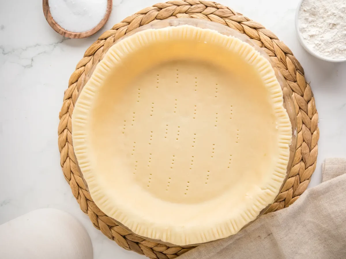 Overhead photo of crisco pie crust in a dish on top of a woven mat