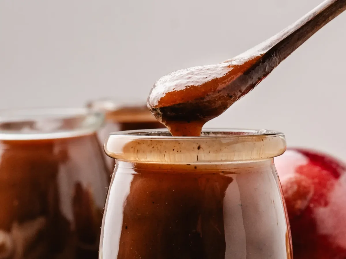 close up photo of apple butter on a wooden spoon