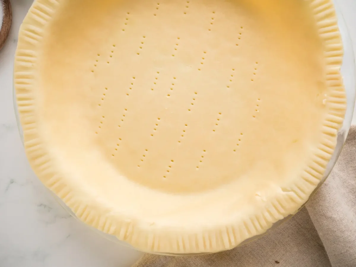 close up photo of pie crust with fork holes and crimped