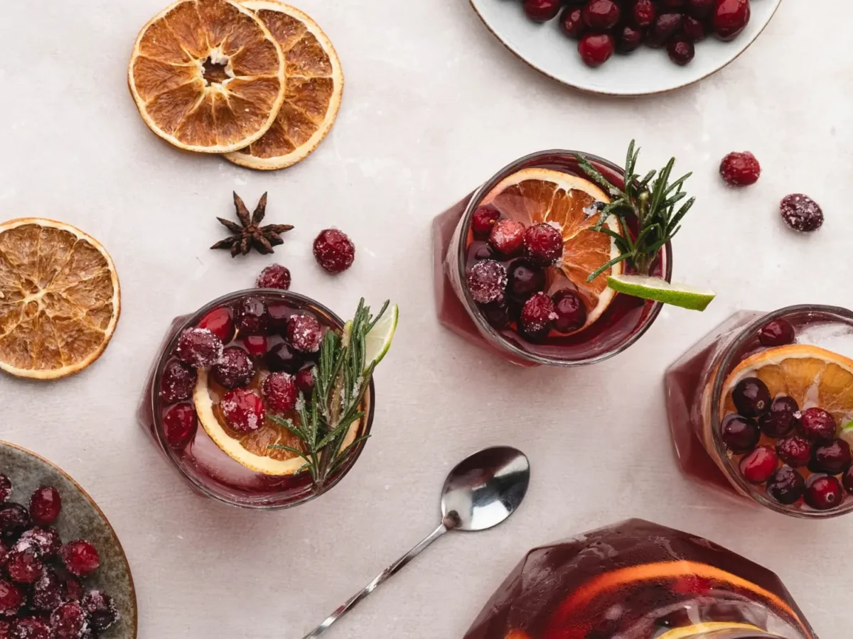 overhead photo of 2 cranberry mocktails with garnishes