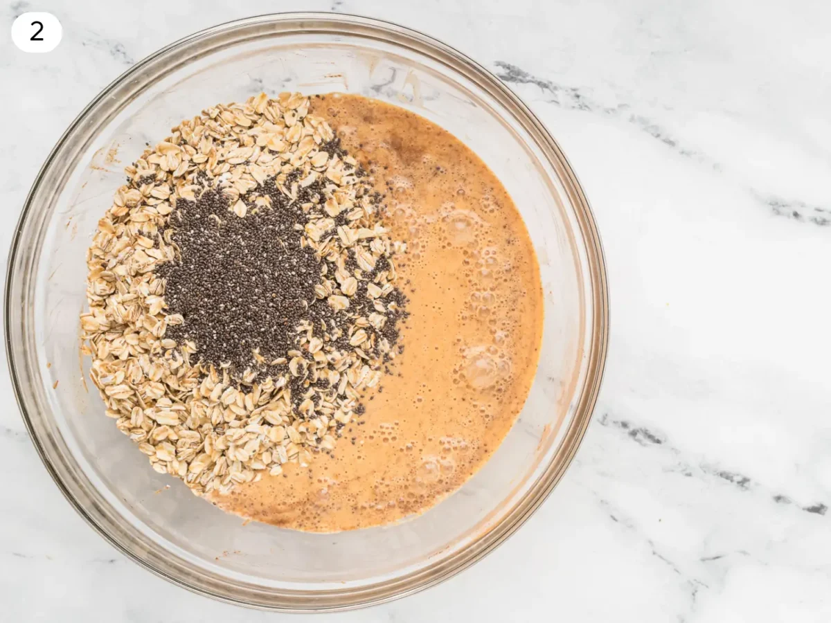 step 2 photo showing chia seeds and oats being added to the glass mixing bowl