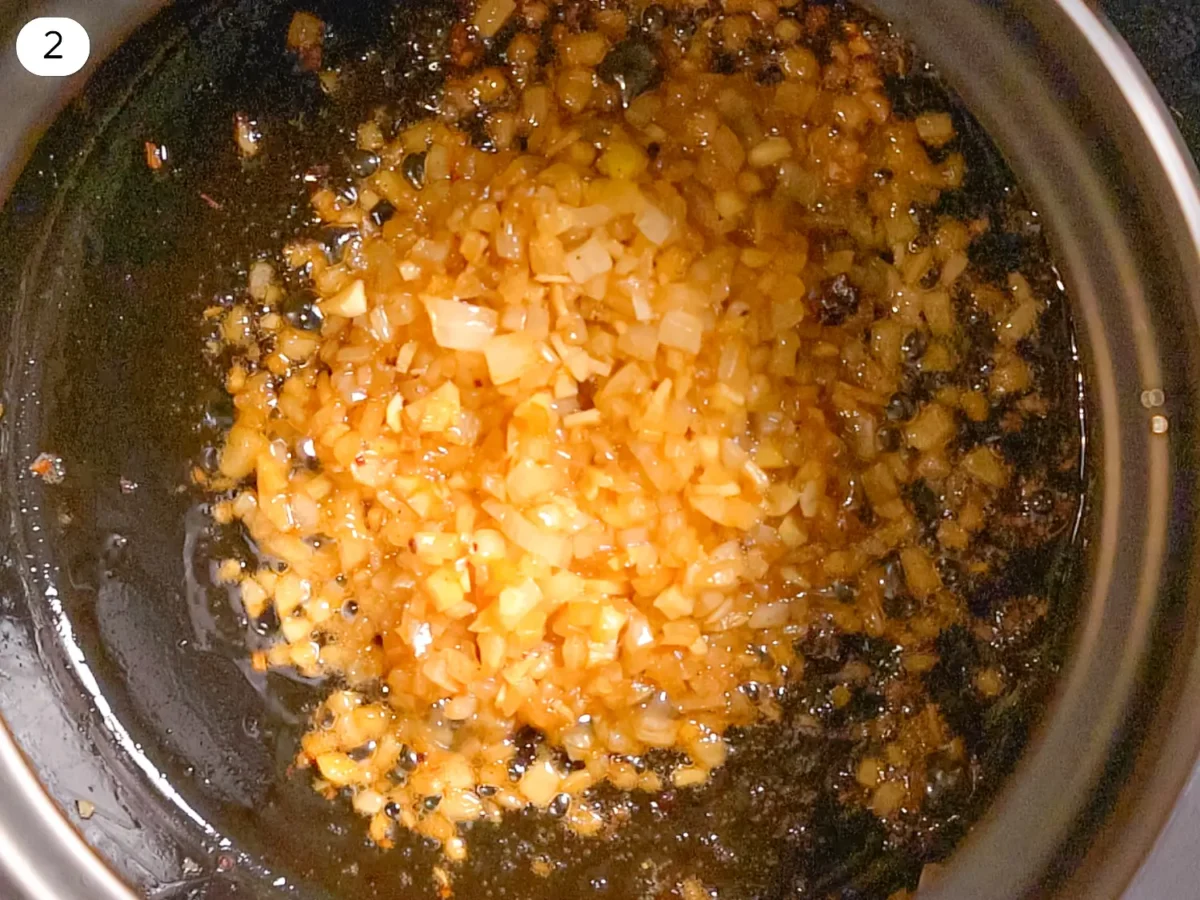 step 2 photo showing onions and garlic cooking in bacon fat